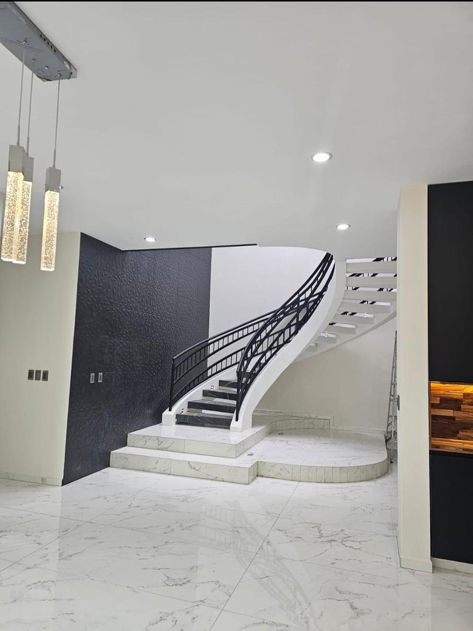 Escalera helicoidal de concreto terminada en el vestíbulo de una casa