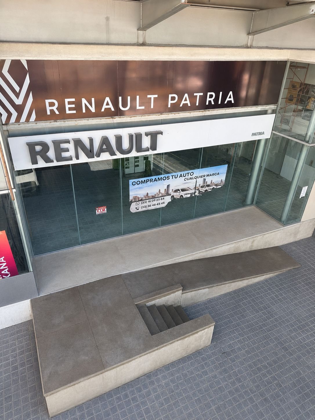 Rampa y banqueta de concreto en el acceso de una agencia automotriz